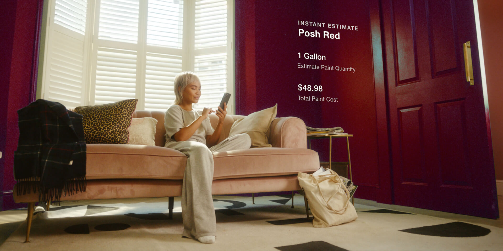 Woman sitting in living room looking at wall paint on Lowes Home Improvements mobile app