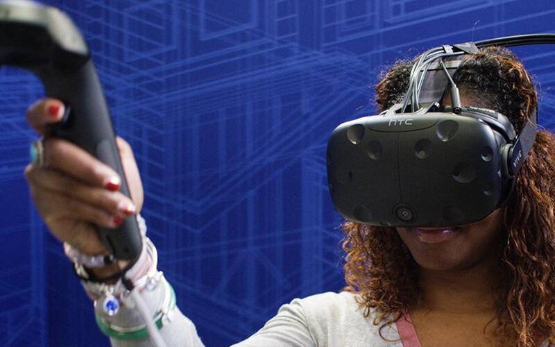 African-American female wearing VR headset learning DIY skills in a Lowes Home Improvement holoroom experience.