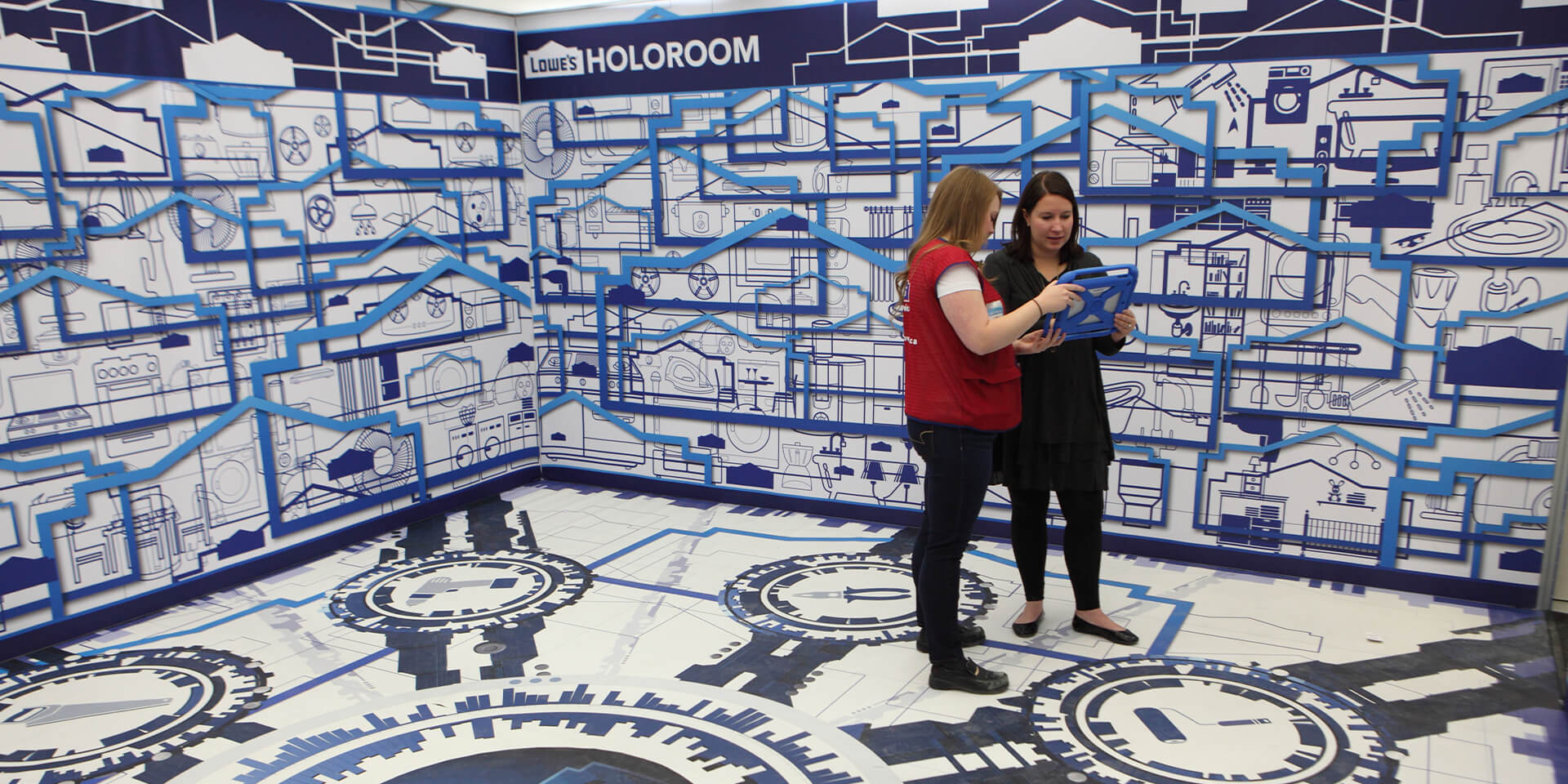 Female Lowes Home Improvement associate showing a female customer how to use the Holoroom VR home improvement design and visualization prototype experience.