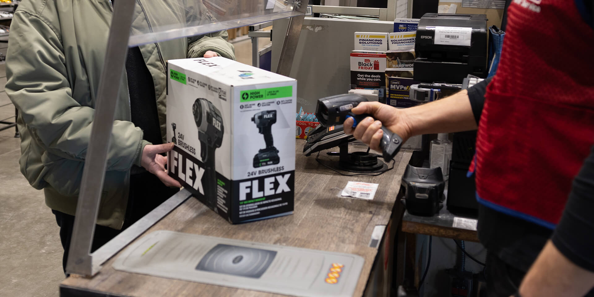 Customer purchasing a Flex brand drill, being checked out by a Lowes Home Improvement associate. 