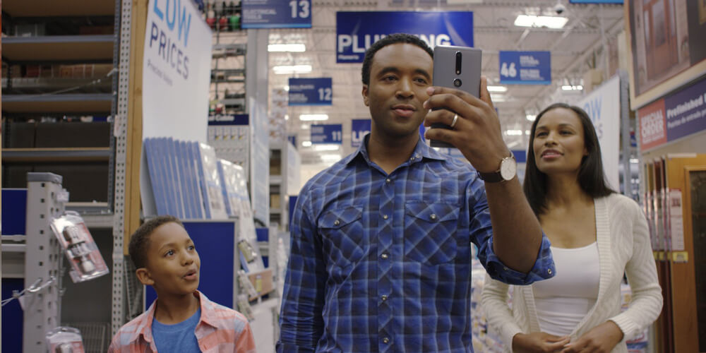 African-American family in a Lowes Home Improvement store aisle using in-store navigation.