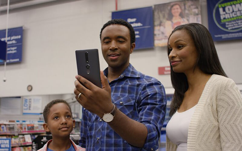 African-American family in a Lowes Home Improvement store using in-store navigation to find what they need.